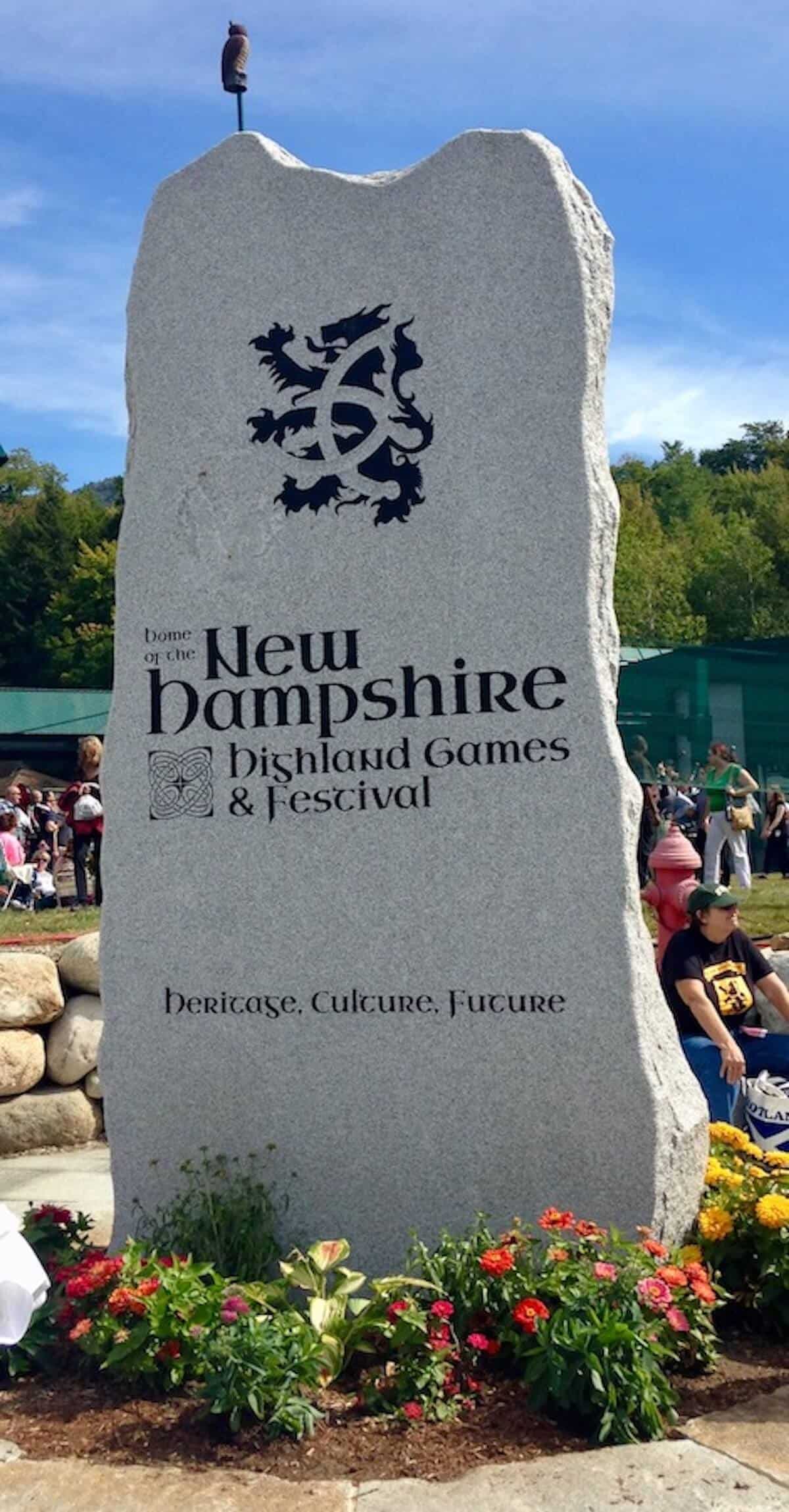 New Hampshire Highland Games & Festival standing stone with flowers at base.