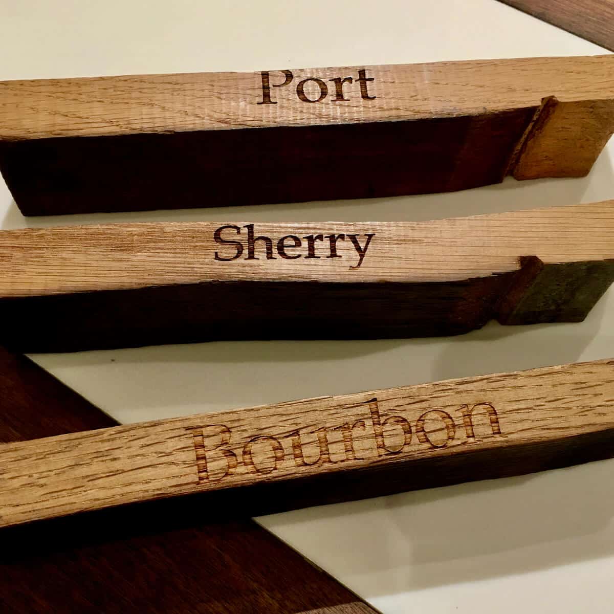 Barrel staves from port, sherry, and bourbon casks on a counter.