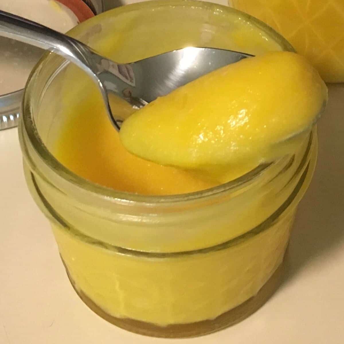Spooned lemon curd over a jar.