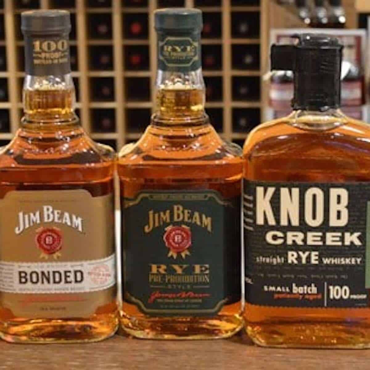 Jim Beam & Knob Creek bourbons and ryes in bottles on a counter.