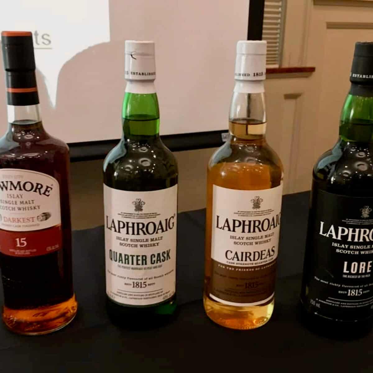 Laphroaig and Bowmore scotch tasting lineup in bottles on a table.