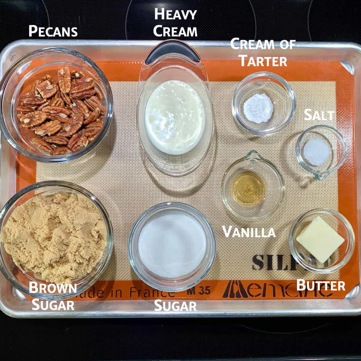 Pecan pralines ingredients portioned in bowls on tray.