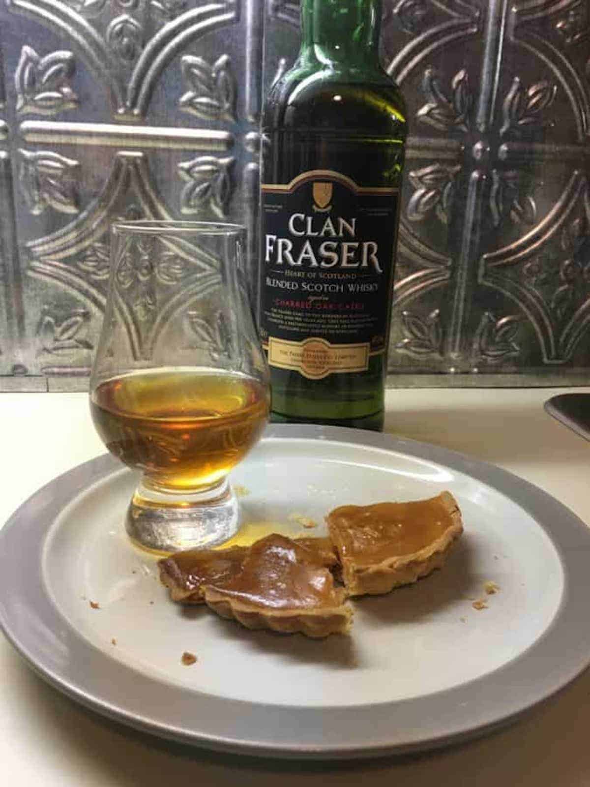 Clan Fraser blended scotch whisky with poured glass & apple cider tart on a plate.