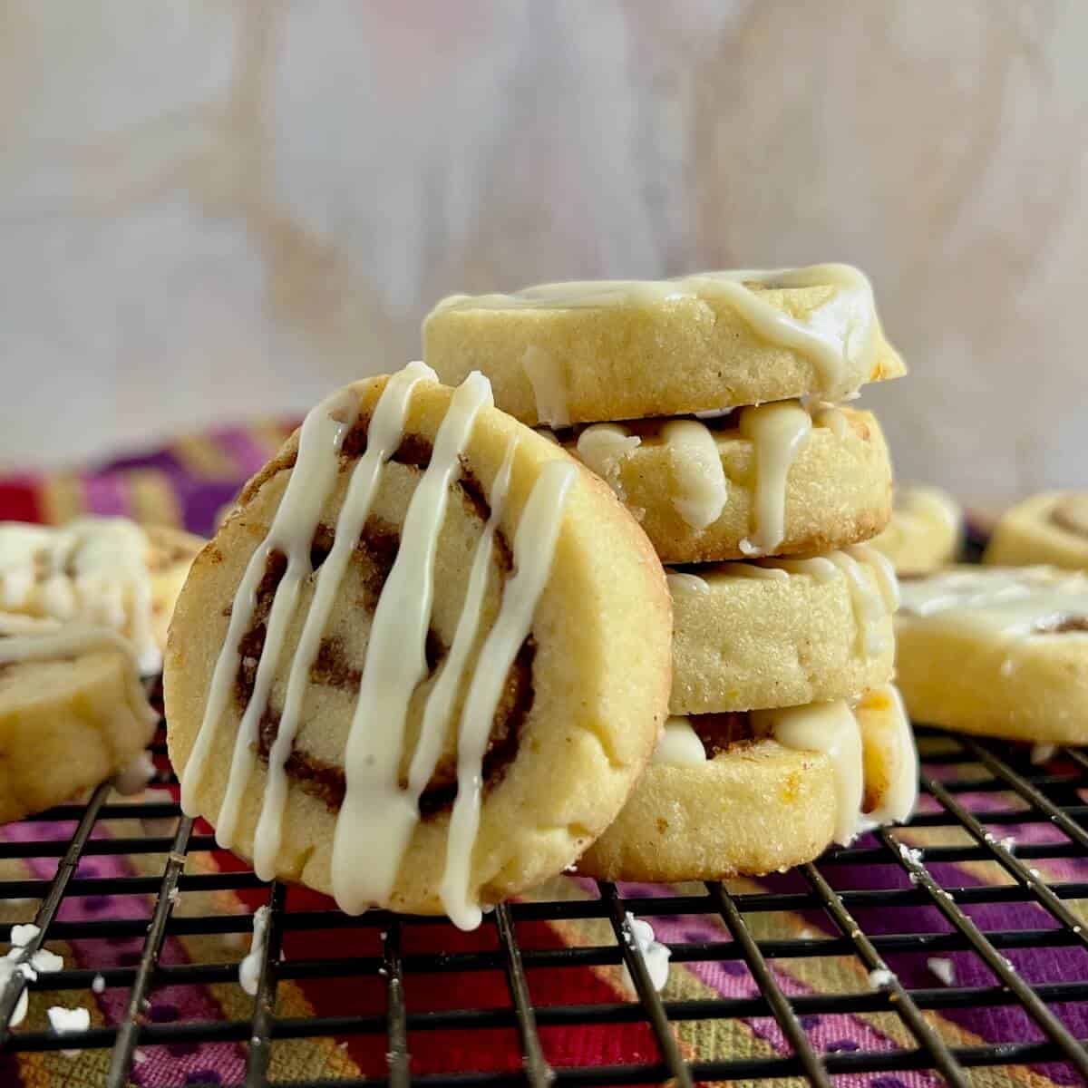 Four Cinnamon roll cookies stacked with one leaning on the stack.