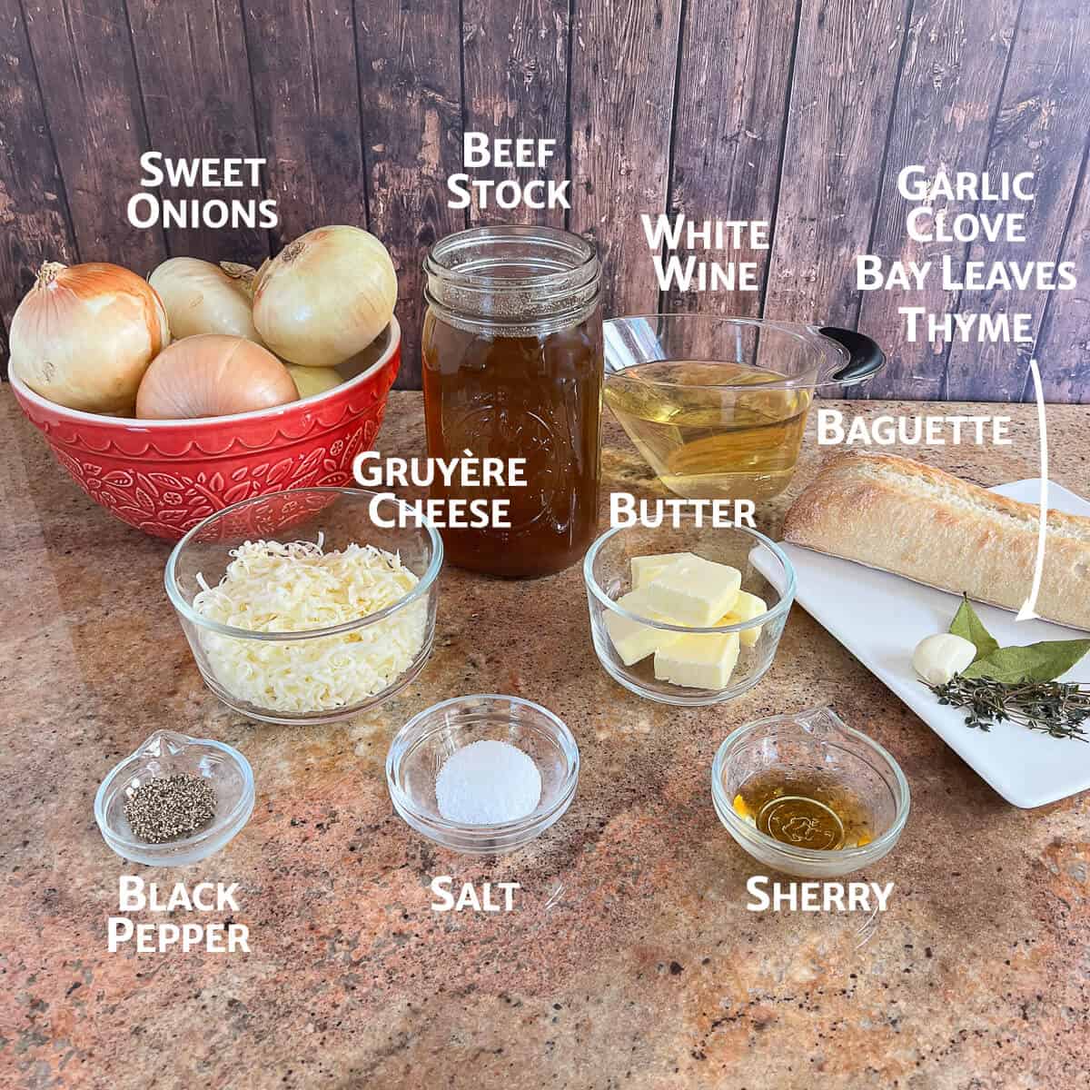 French Onion Soup ingredients portioned into glass bowls on a counter.