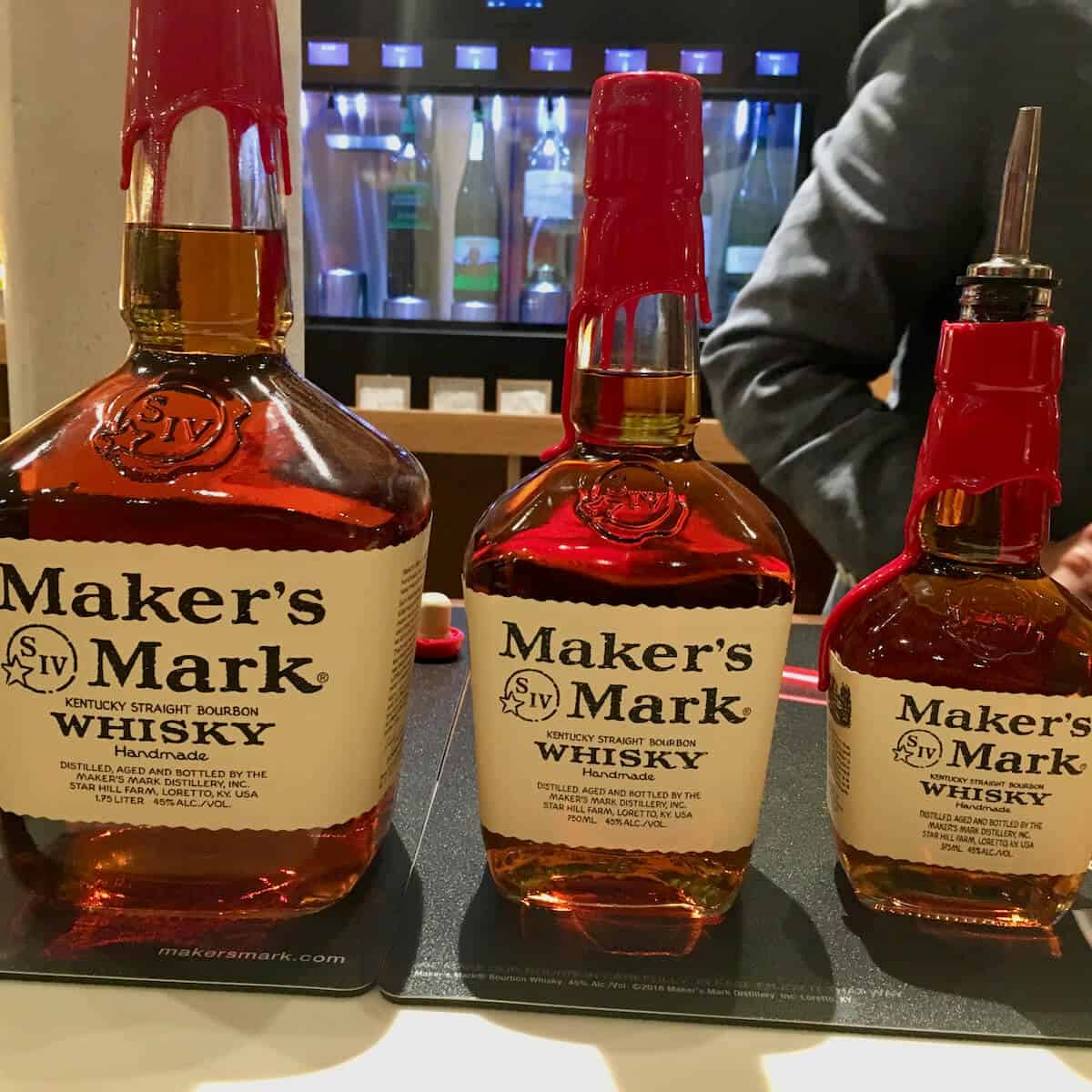 Three sizes of Maker's Mark bottles on a counter.