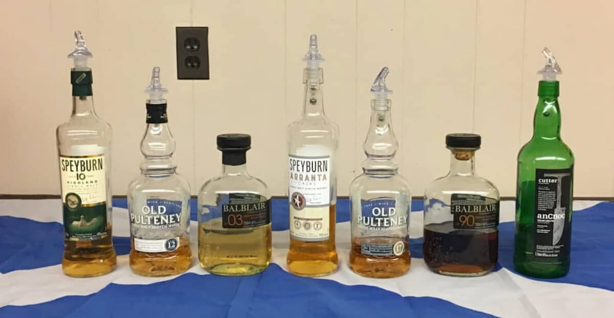 375 Park Ave Spirits Single Malt Scotch Tasting lineup in bottles on a Scottish flag.