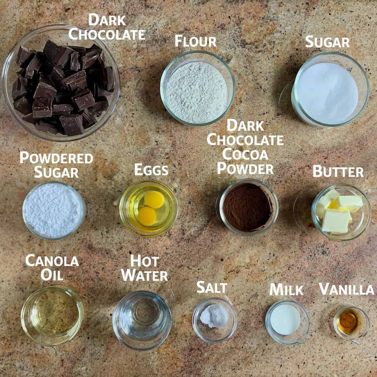 Ingredients for chocolate cake truffles portioned in glass bowls from overhead