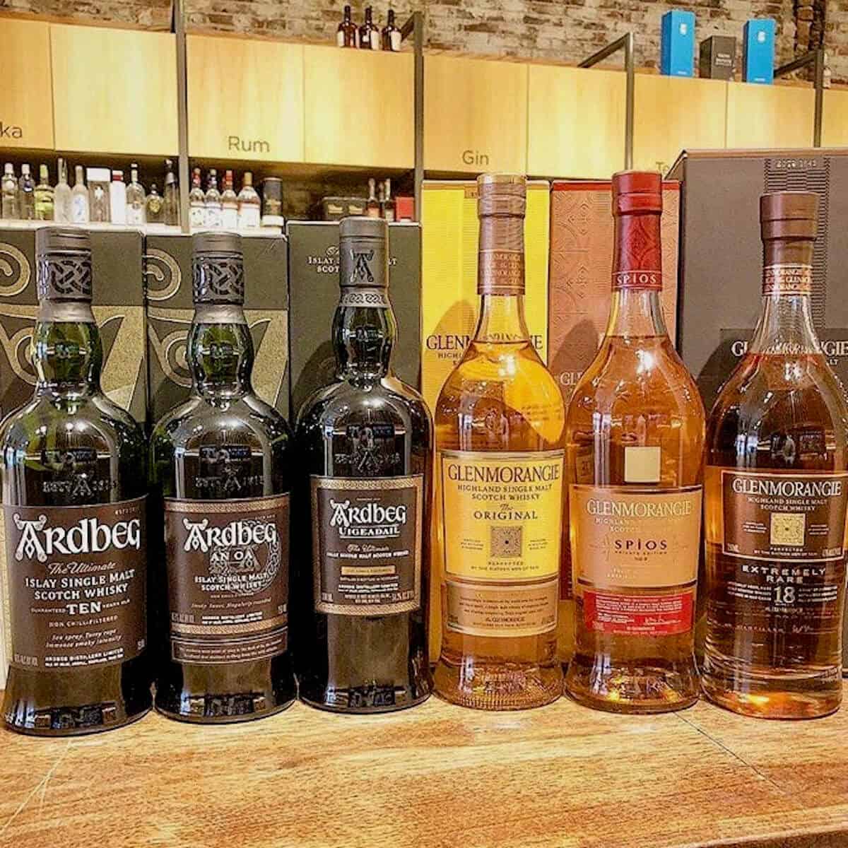 Glenmorangie and Ardbeg lineup in bottles on a counter.