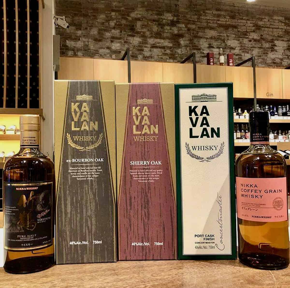 Kavalan & Nikka whisky tasting lineup in boxes on a table.