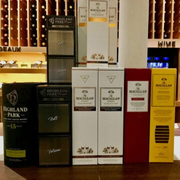 Macallan and Highland Park lineup in boxes on a counter.