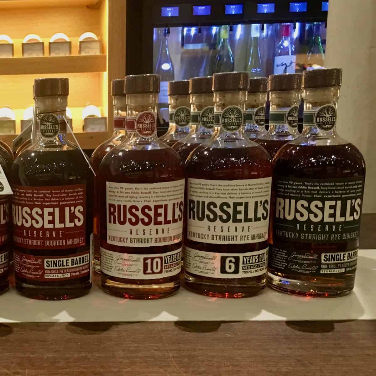 Russell's Reserve 10 year Bourbon, 6 year Rye, and Straight Rye in bottles on a counter.