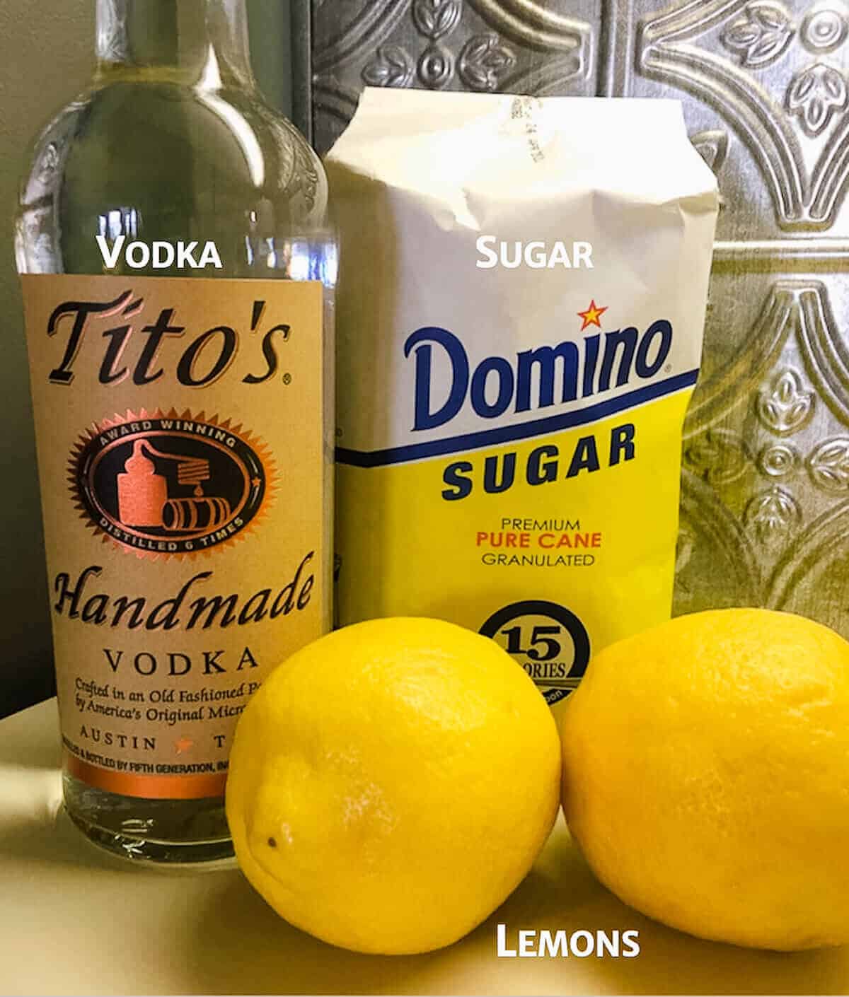 Vodka and sugar in their packaging with 2 lemons.