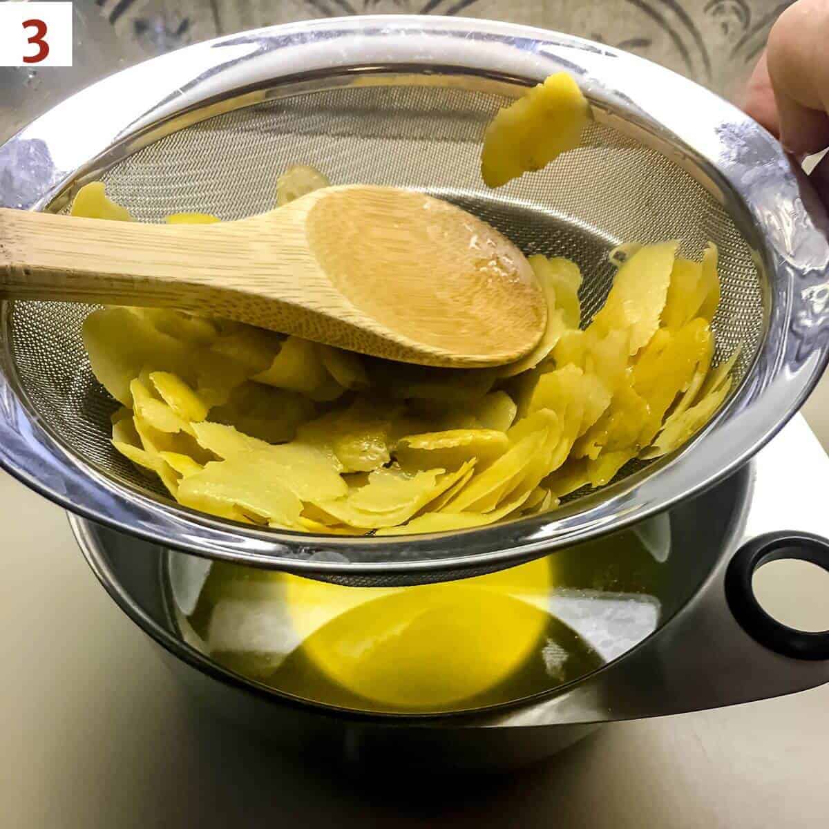 Straining the limoncello infusion into a bowl.