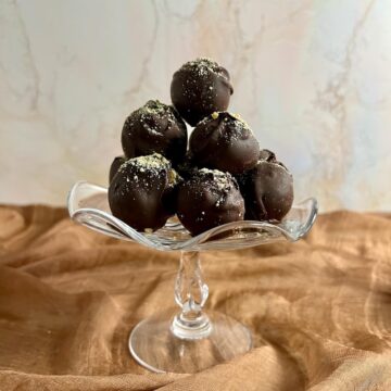 Tiramisu truffles stacked on a glass stand.