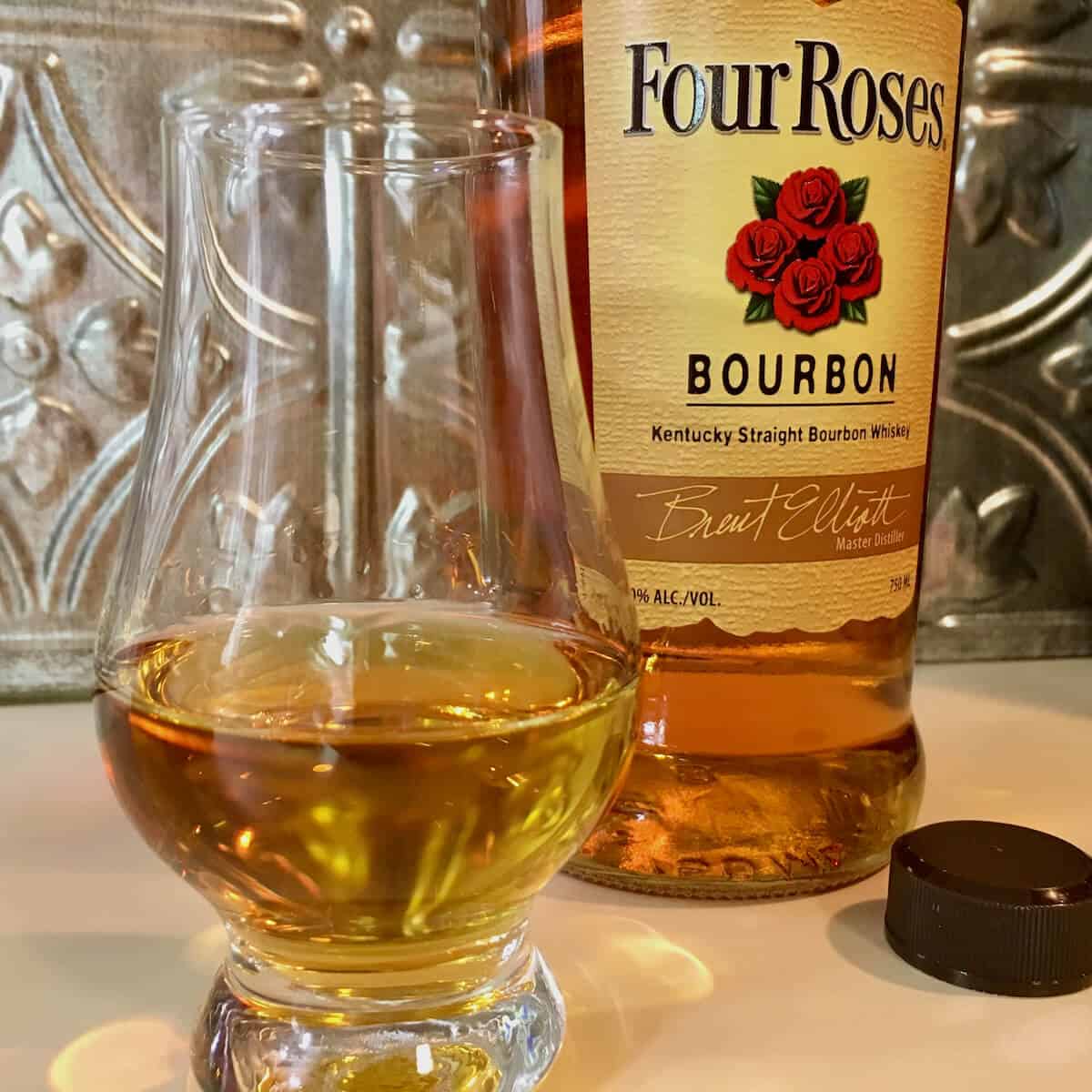 Four Roses Bourbon bottle behind a poured glass.