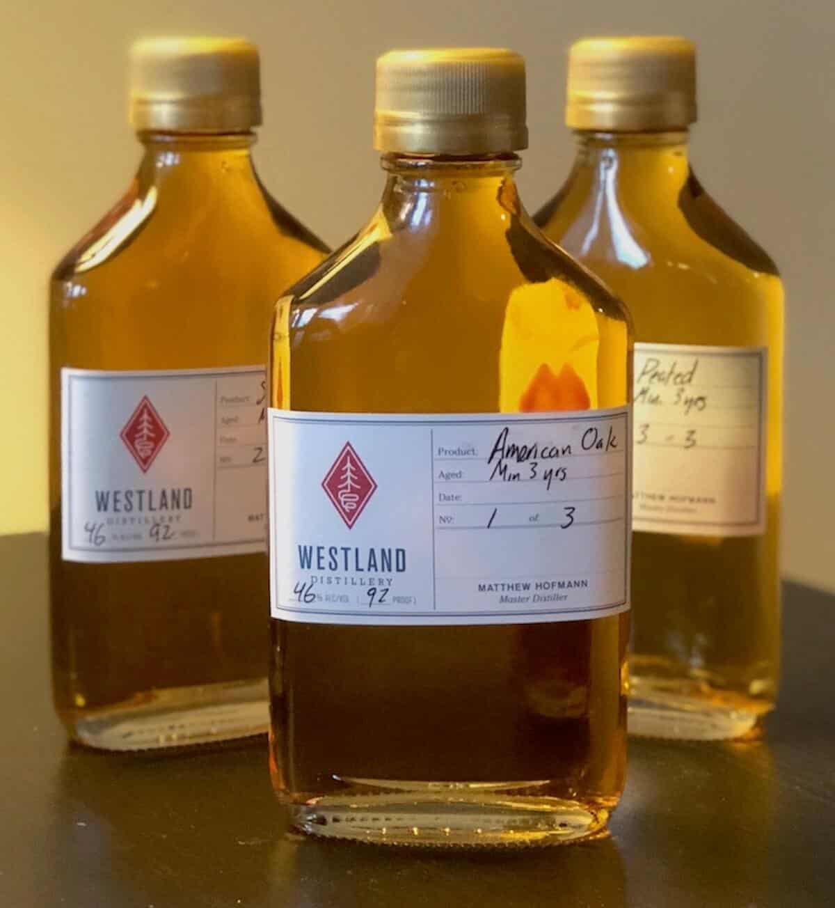 Westland American Single Malt sample bottles on a table with American Oak in foreground.