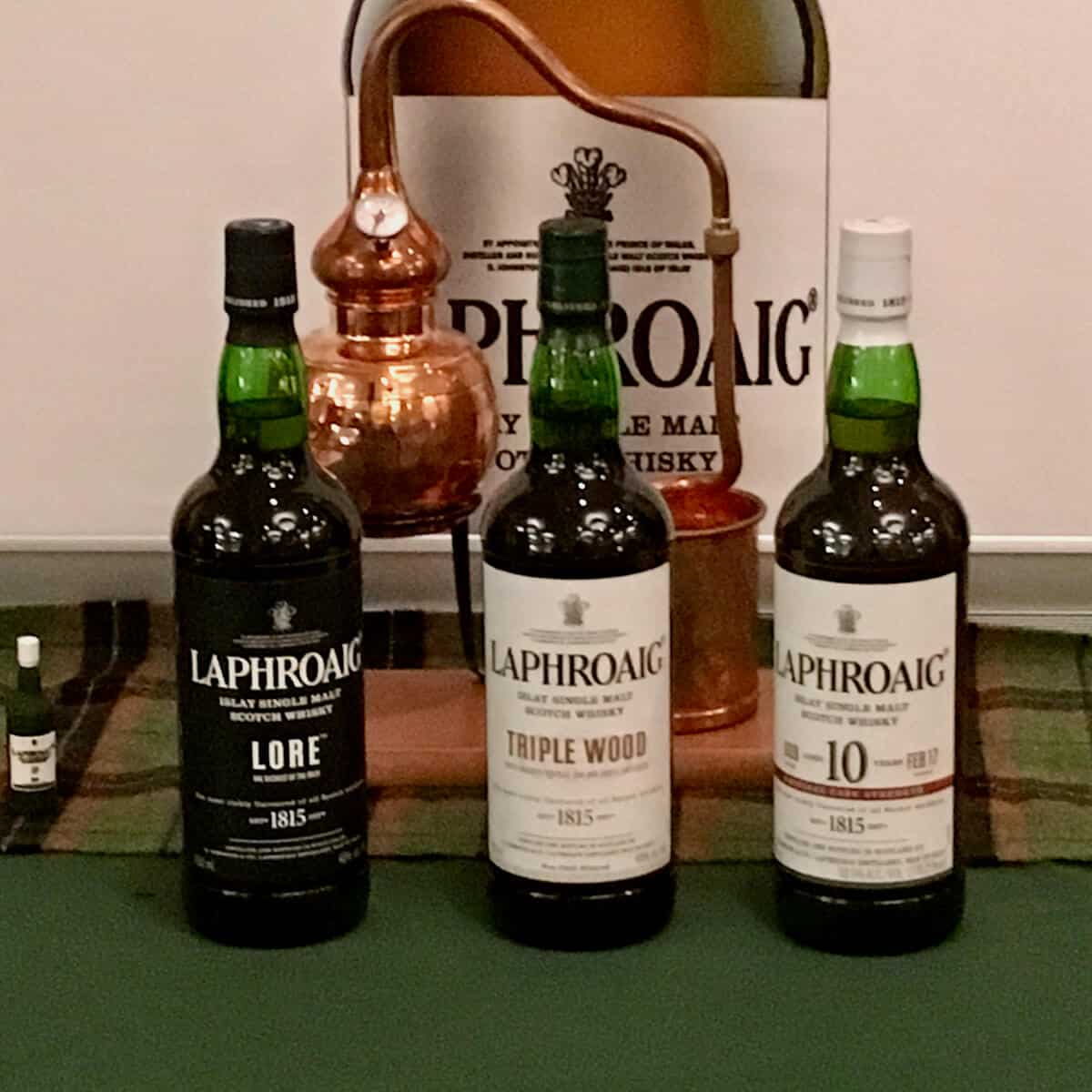 Laphroaig lineup in bottles with model of a pot still.