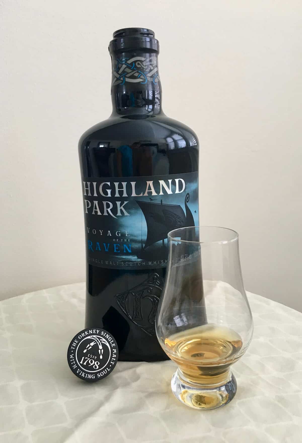 Highland Park Voyage of the Raven in bottle with a poured glass on a table.