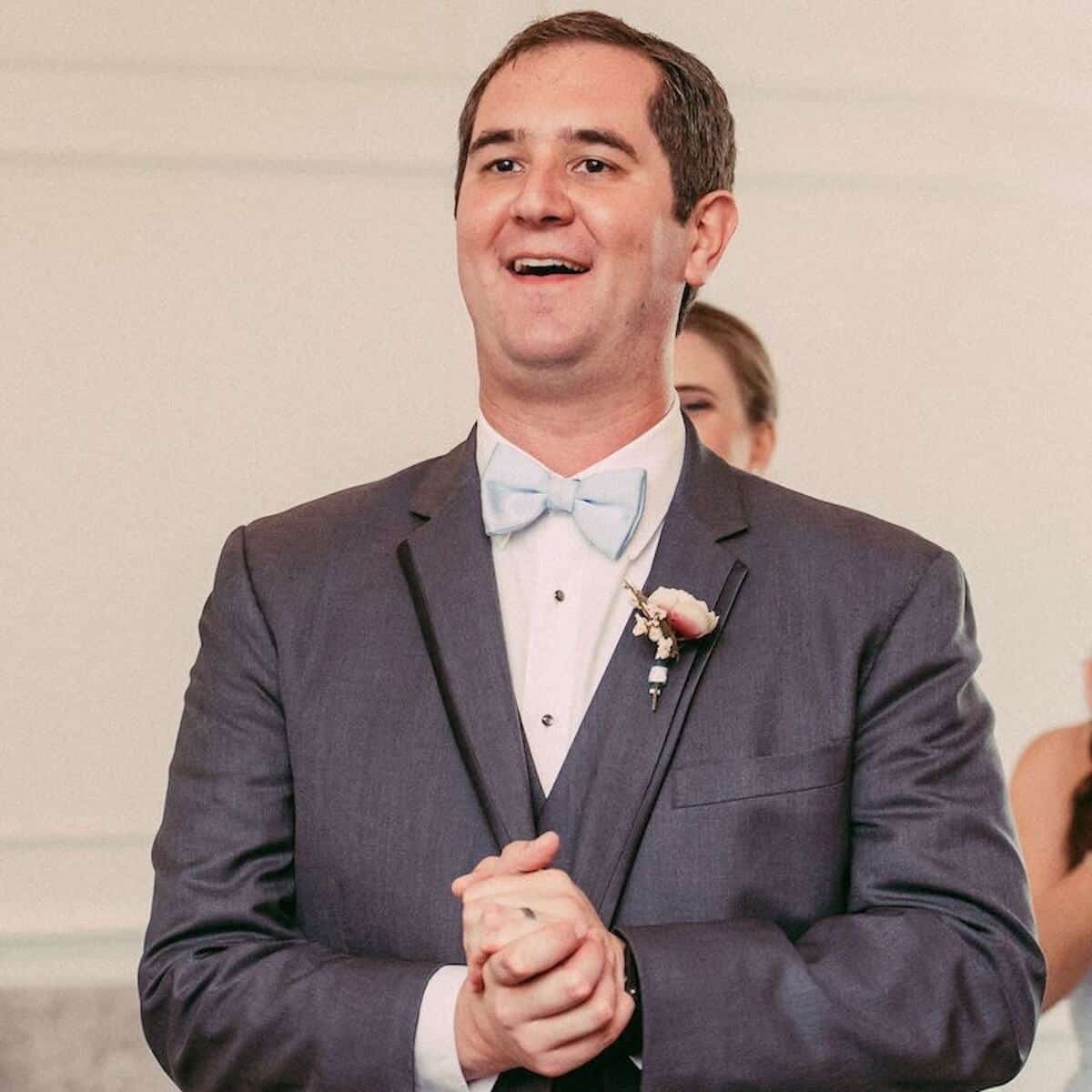 The groom reacting to his groom's TARDIS cake being wheeled out.