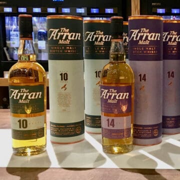 Bottles & sleeves of Arran Malt 10 year and 14 year on a counter