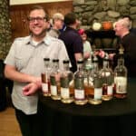 Joshua Hatton with the Exclusive Malts lineup in bottles on a table.