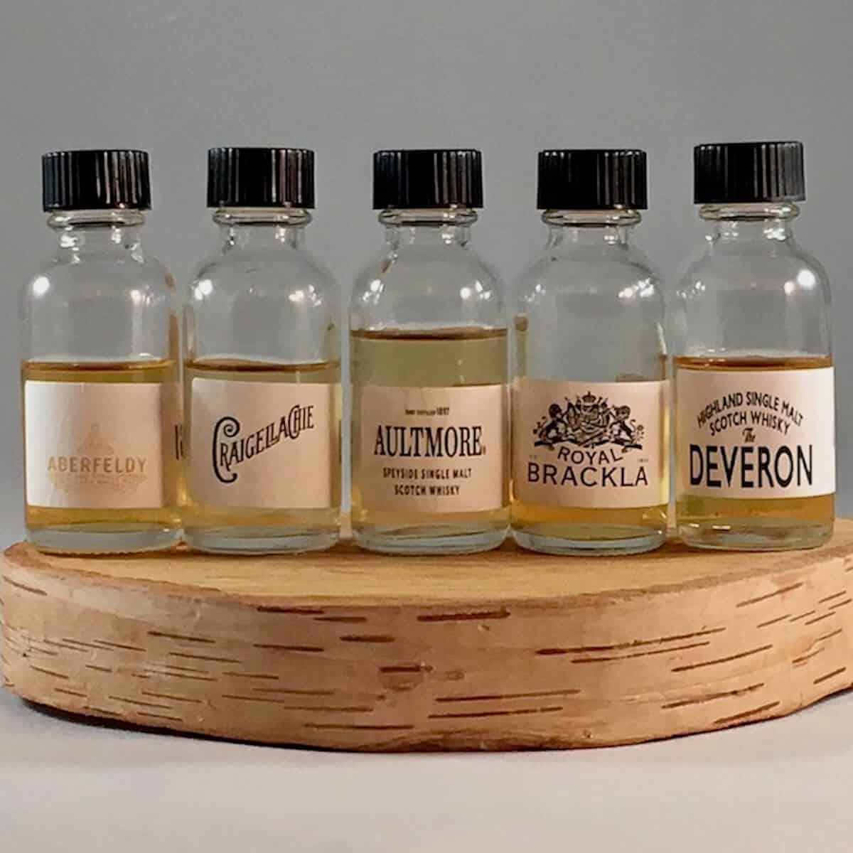 John Dewar & Sons Fine Scotch Whisky Emporium lineup in sample bottles on a wooden tray