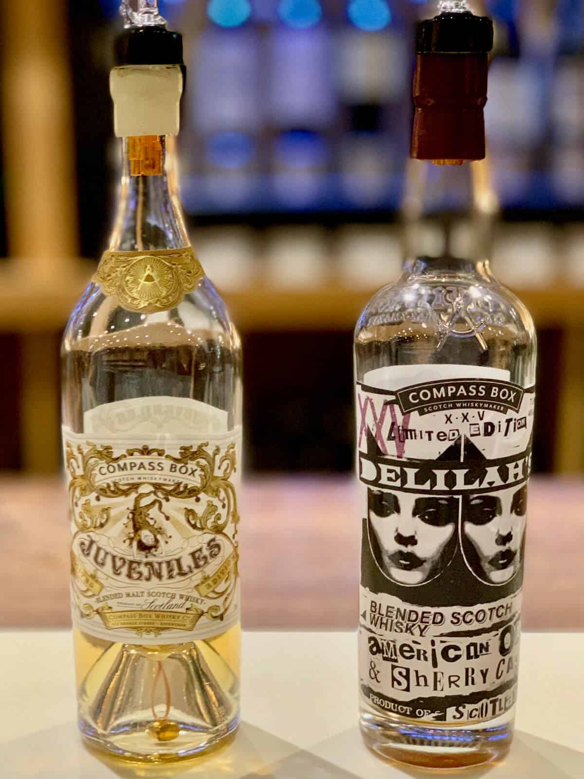 Compass Box Blended Scotch Juveniles and Delilah 25 in bottles on a counter.