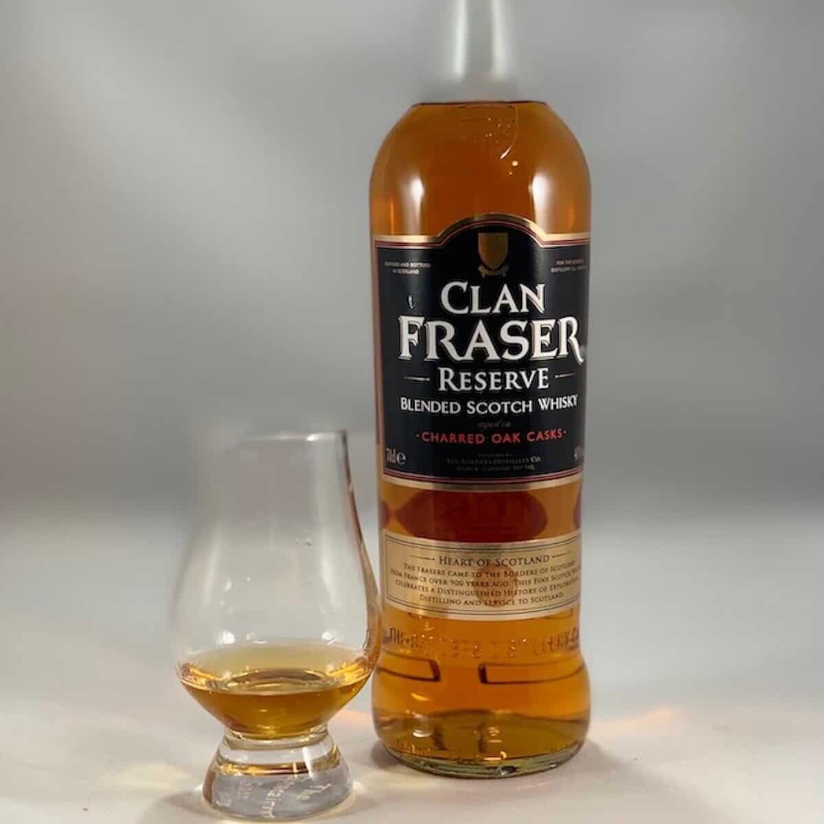 Clan Fraser Reserve blended scotch bottle with poured glass next to it.