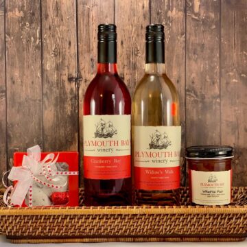 Widow’s Walk & Cranberry Bay table wines, with jar of jelly & candy in a basket.