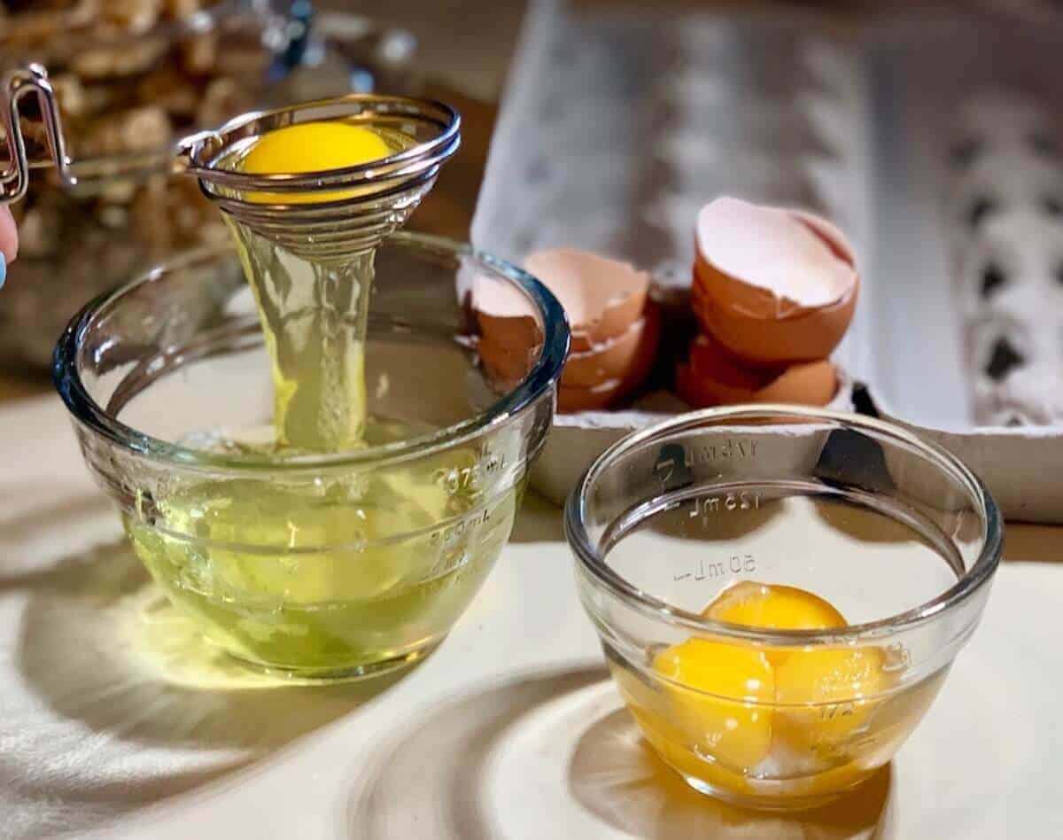 Separating eggs using an egg separator into glass bowls.