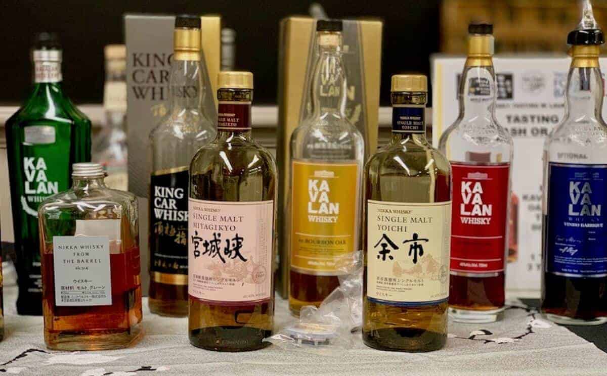 Kavalan Taiwanese whiskey, Nikka Japanese whisky tasting lineup in bottles on a table.