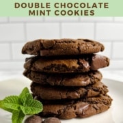 Stack of Double Chocolate Mint Cookies on a white plate with mint and chocolate wafers Pinterest banner.