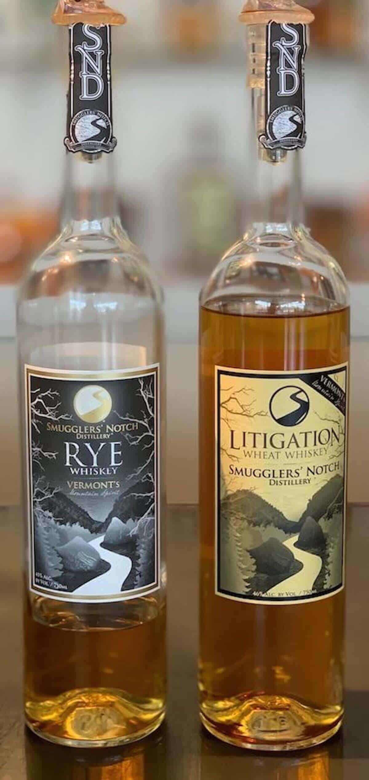 Smugglers' Notch Distillery Litigation wheat whiskey & rye whiskey on counter.