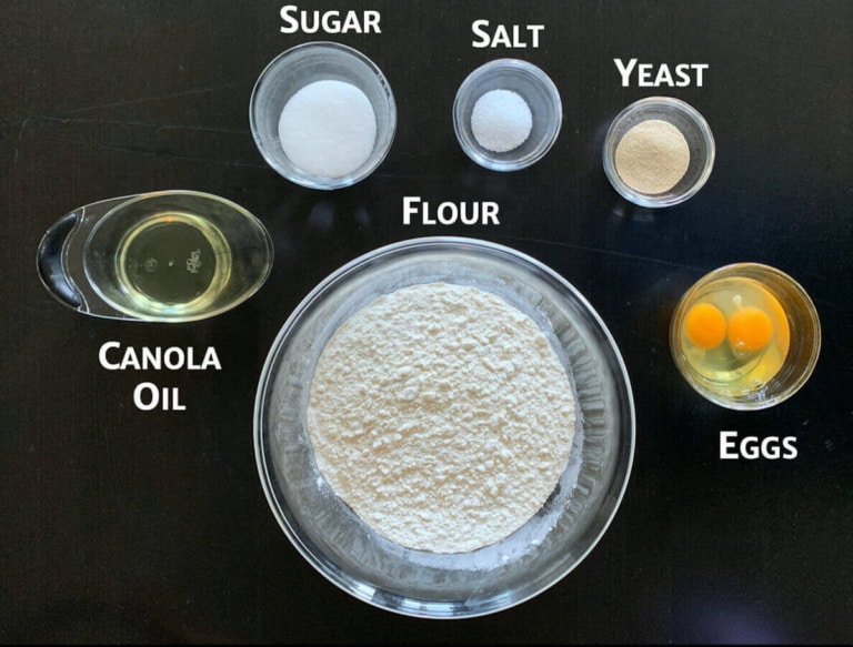 Challah dough ingredients portioned into glass bowls.