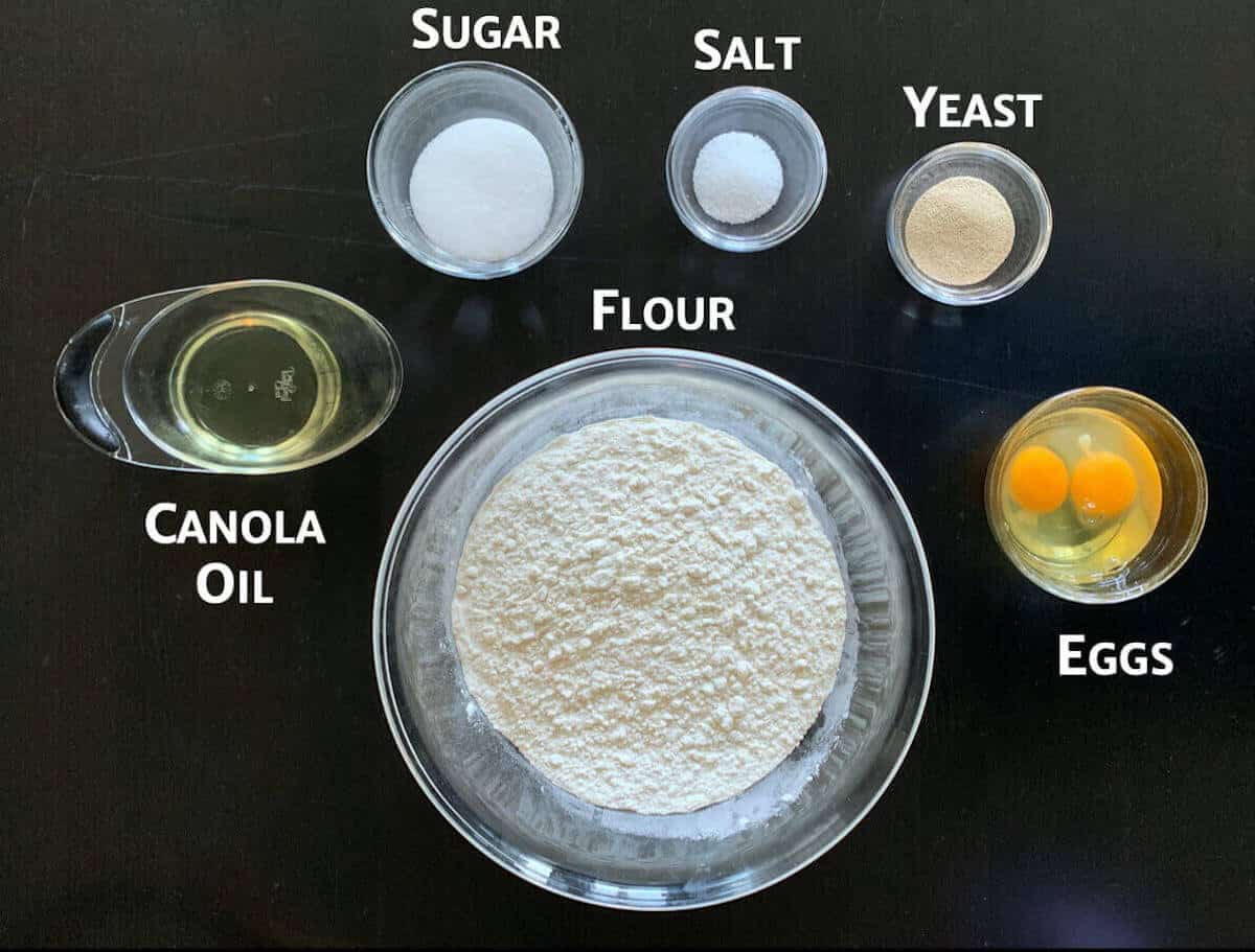 Challah dough ingredients in portioned in glass bowls.