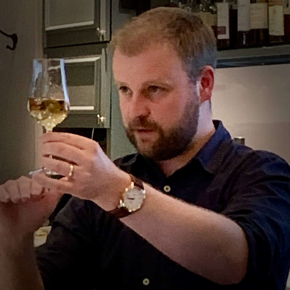 Adam Hannett, Bruichladdich's Head Distiller, looking at a glass of scotch.