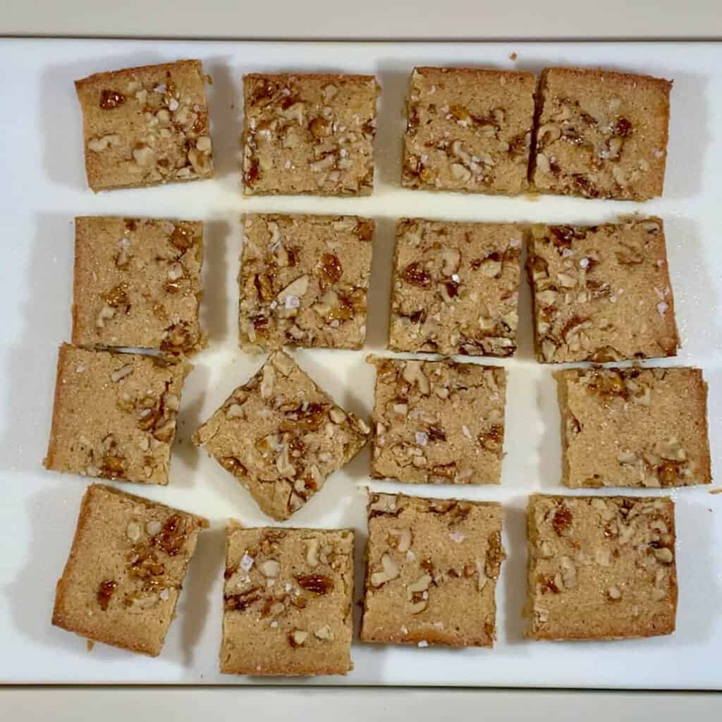 Maple Walnut Bourbon Blondies cut on white cutting board.