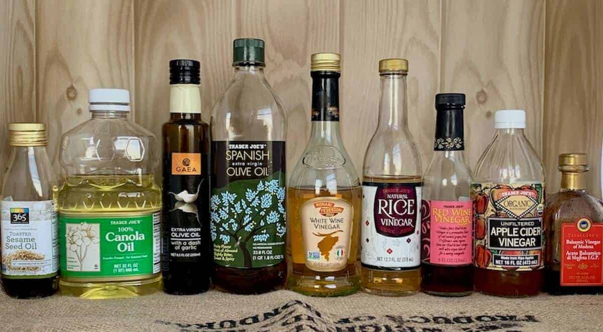 Lineup of assorted oils and vinegars in bottles.