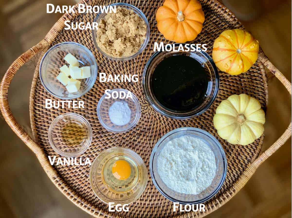 Shoofly Pie ingredients portioned in glass bowls on a wooden tray with pumpkins.