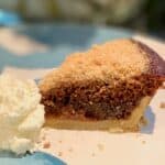 Slice of mini Shoofly Pie slice with whipped cream on a blue & white plate.
