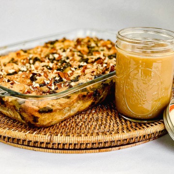 Chocolate Chip Bread Pudding with sauce on a wooden tray.