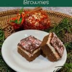 Double chocolate mint brownies on a white plate with greenery & Christmas sachet on a wooden tray Pinterest banner.