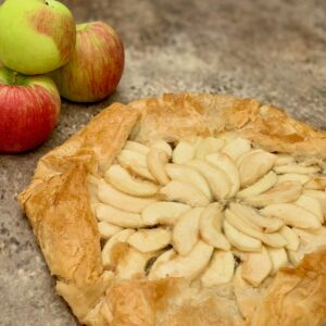 Apple galette with apples on a brown background.