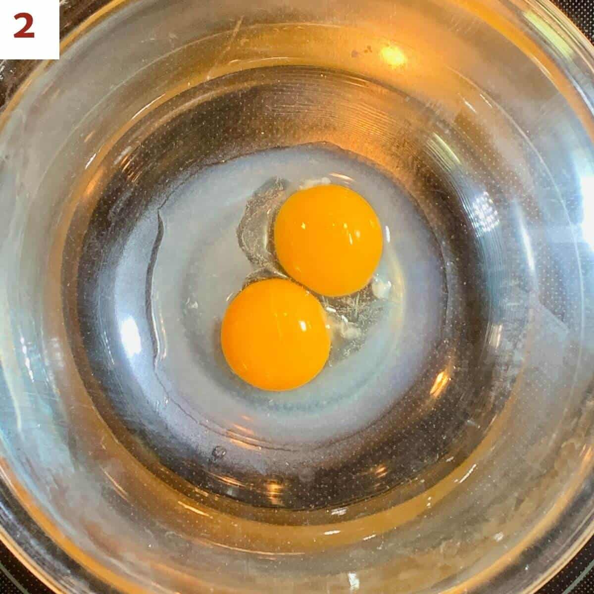 Egg yolks and lemon juice in a metal bowl.