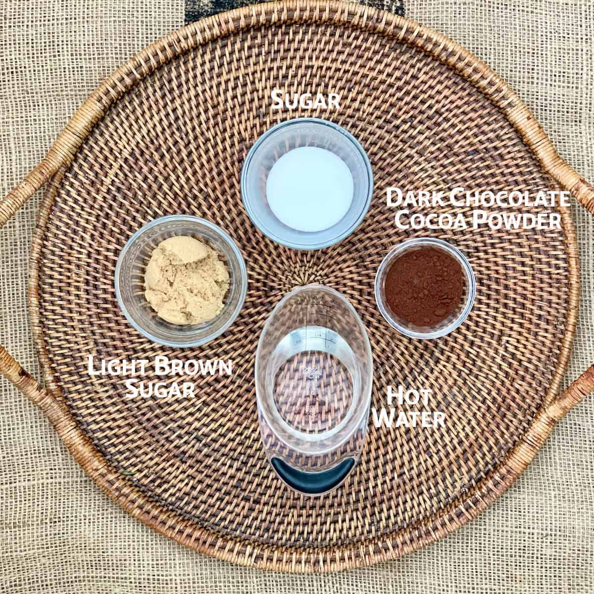 Pudding cake topping ingredients portioned in glass bowls on wooden tray from overhead.
