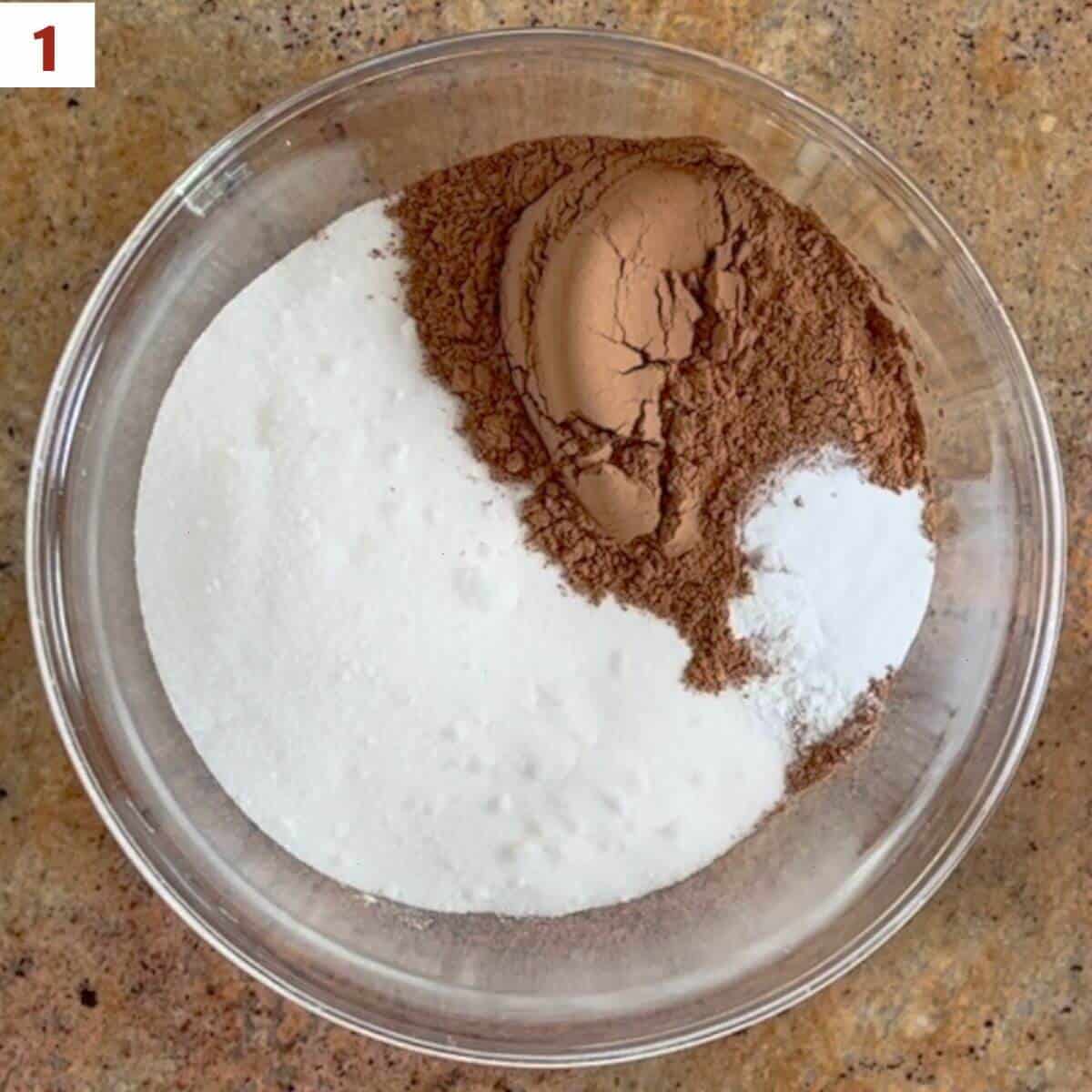 Mixing flour, sugar, cocoa powder, baking powder, baking soda, and salt in a glass bowl.