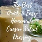 Jar of Caesar salad dressing on a counter with garlic & green salad Pinterest banner.