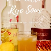 Limoncello Rye Sour in a glass with a lemon and bottles of Limoncello & Rye Whiskey Pinterest banner.