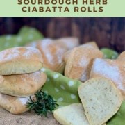 Sourdough Herb Ciabatta Rolls stacked next to a rolls cut open with rolls on a green spotted towel behind Pinterest banner.